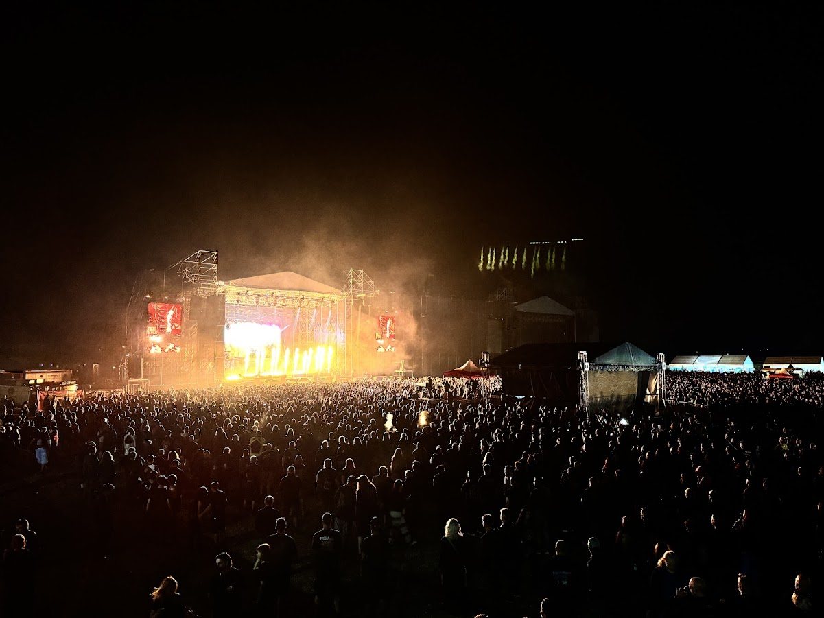 Mulțime de spectatori seara, în fața unei scene de concert luminate