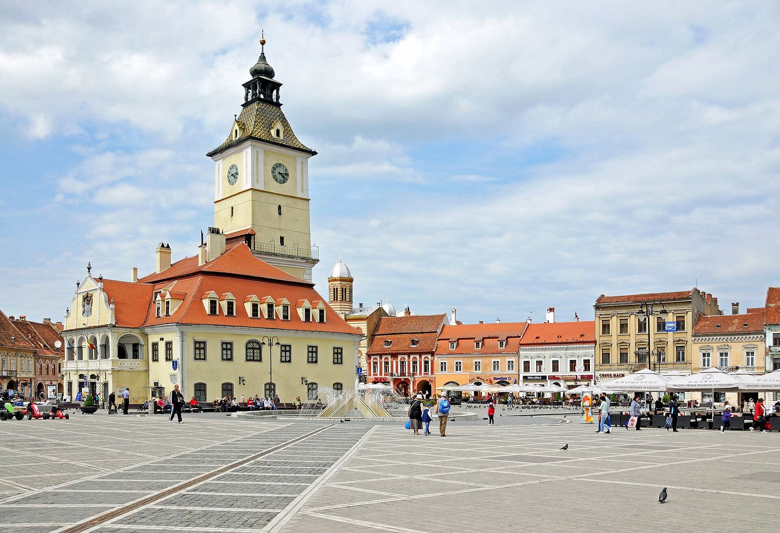 Piața Sfatului din Brașov, cu Casa Sfatului și turnul ei cu ceas, între case istorice colorate